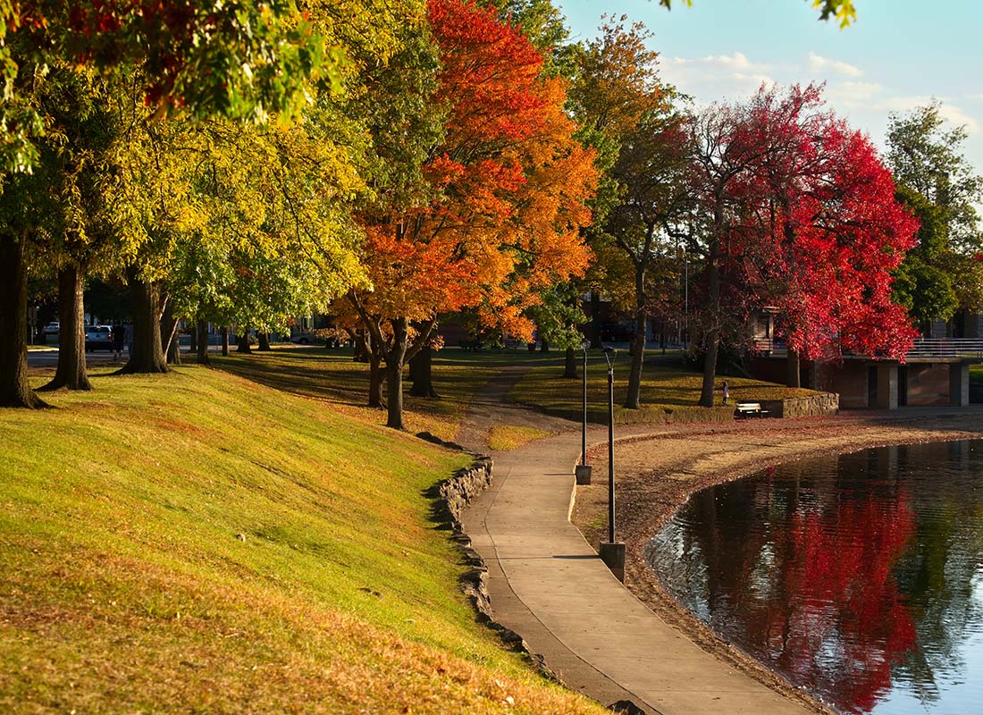 Barberton, OH - Scenic View of Fall Colored Trees in a Park with a Walking Trail by the Lake in Barberton Ohio